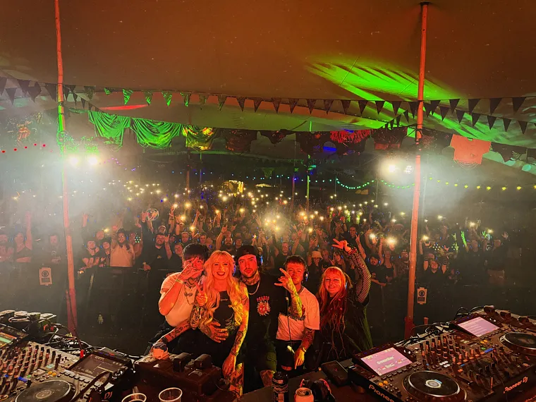 The view from the DJ booth out over a packed room under green lasers